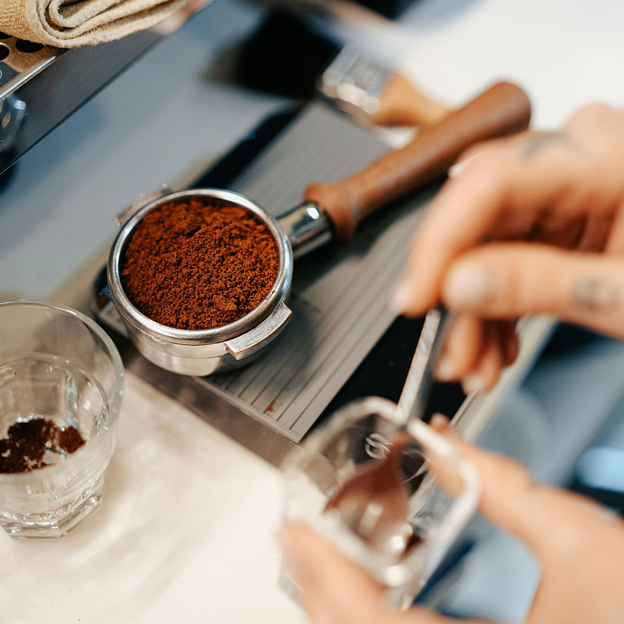 Person preparing espresso shot for coffee machine.
