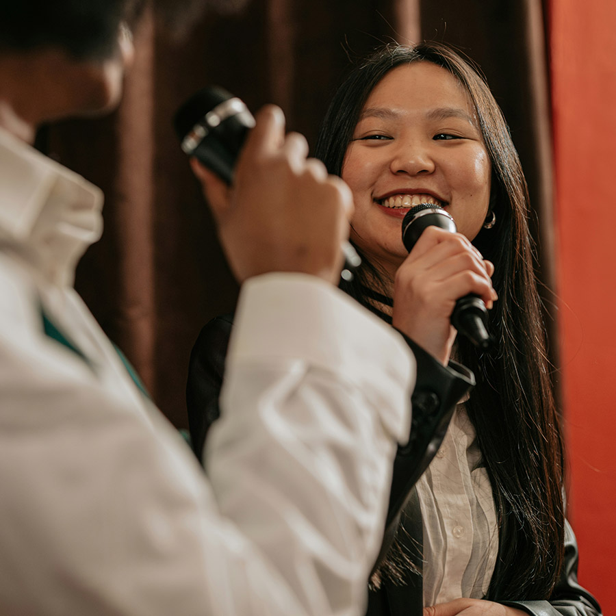 Two stand up comedians laughing together on stage.