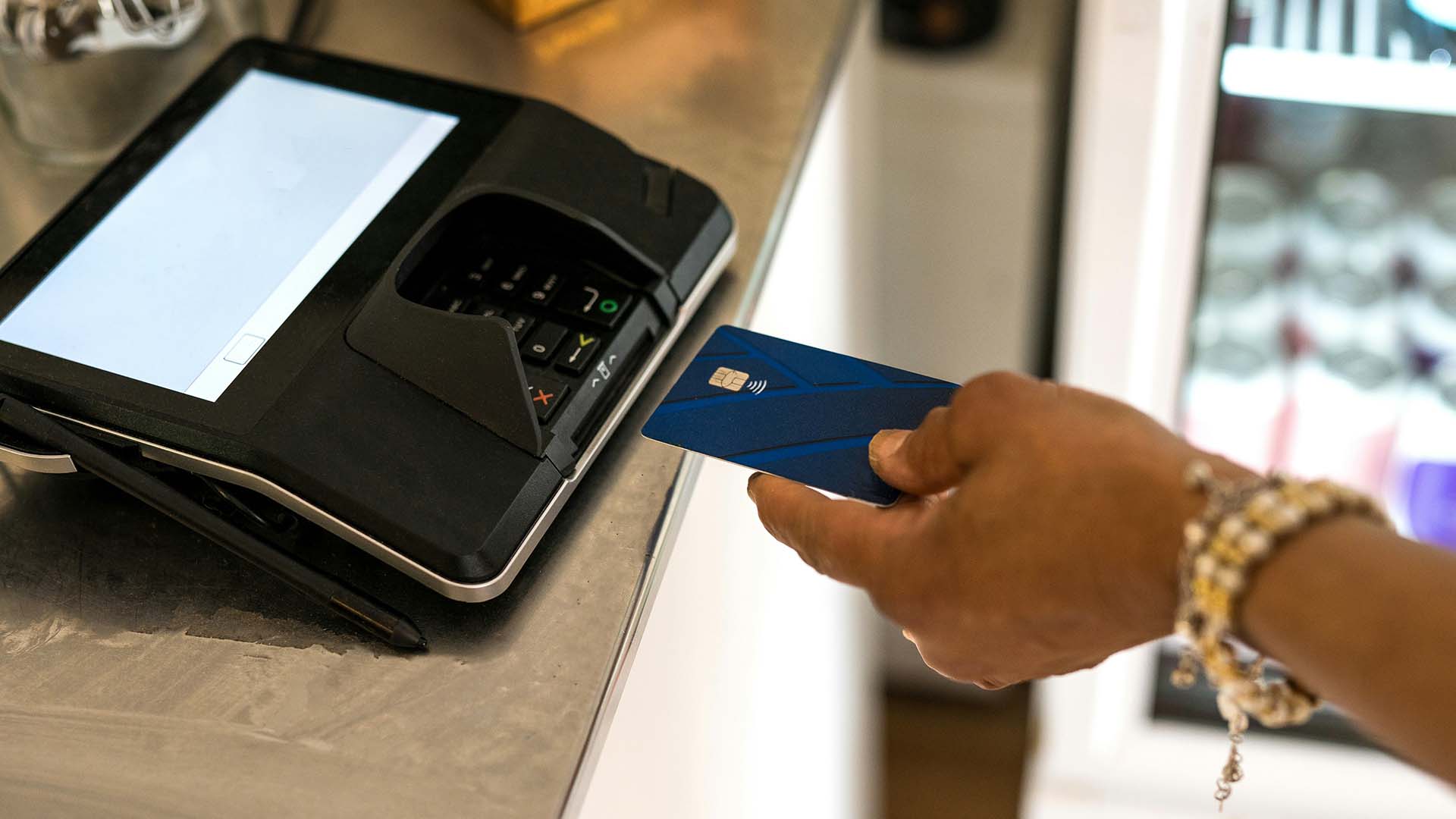 Person paying for good with debit card in store.