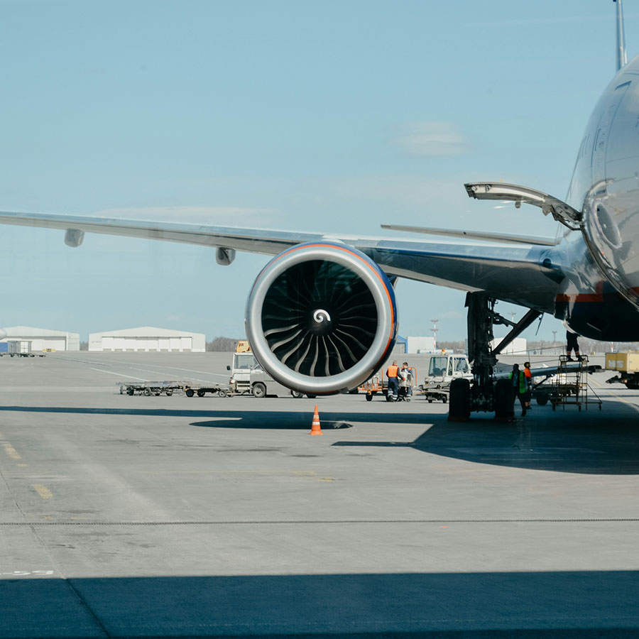 Airplane loading luggage at an airport terminal.