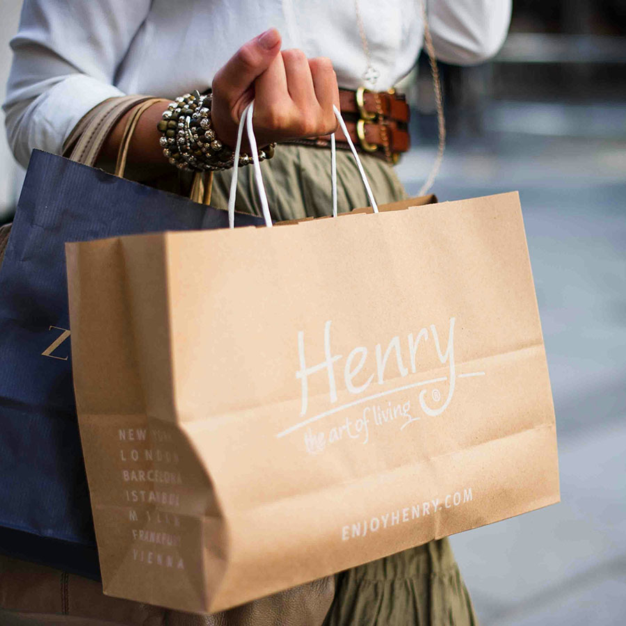 Person holding shopping bags at outdoor mall.