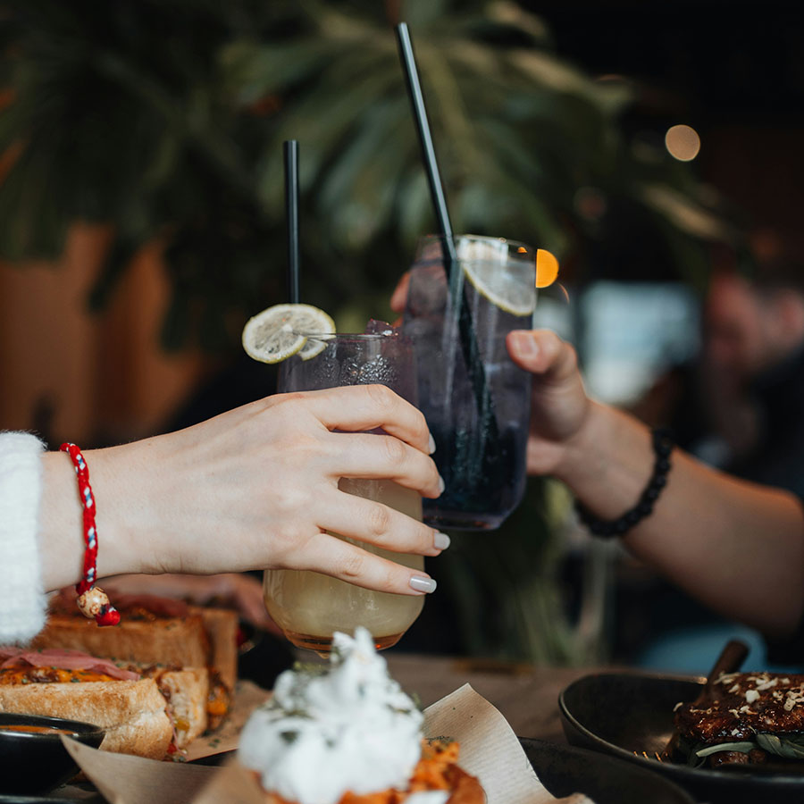 Friends toasting together with cocktails at brunch.