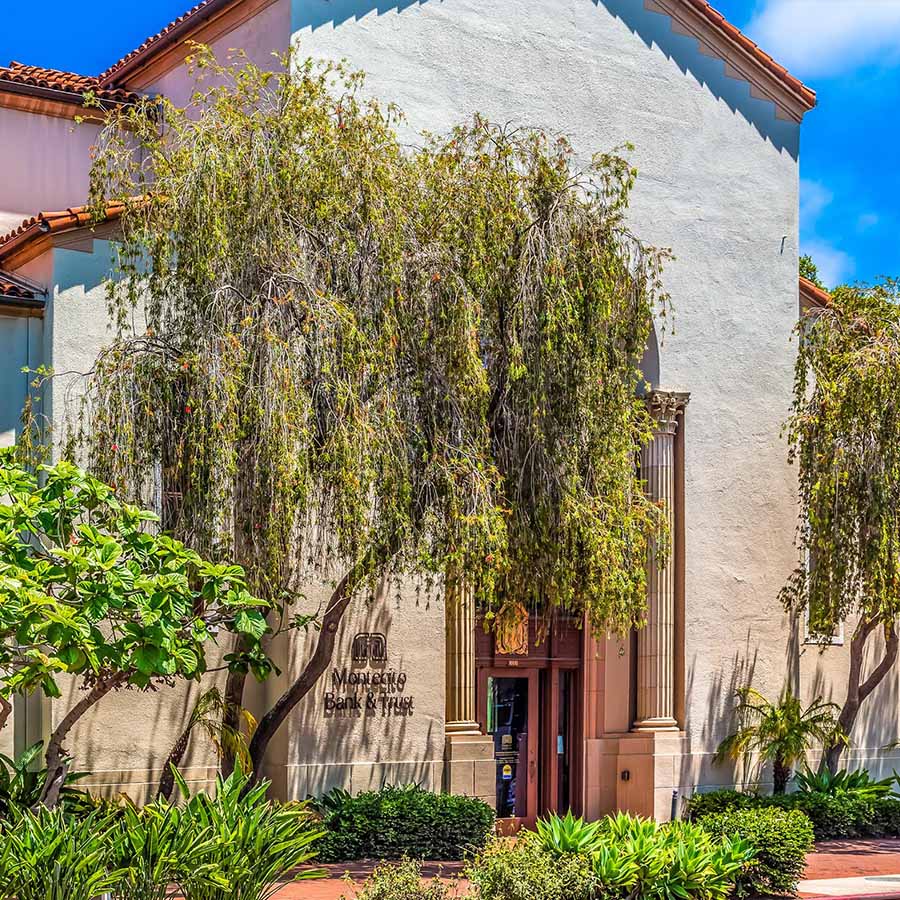 Montecito Bank & Trust building with lush green trees.