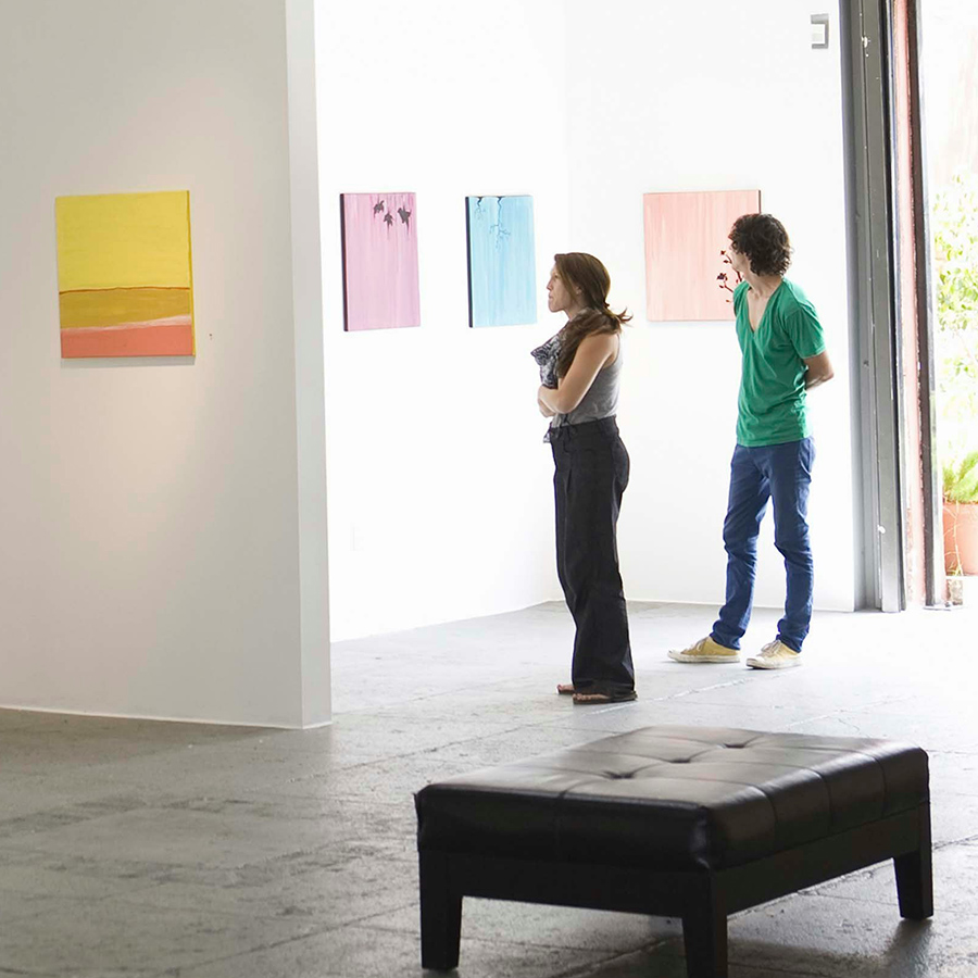 People looking at paintings in art museum.