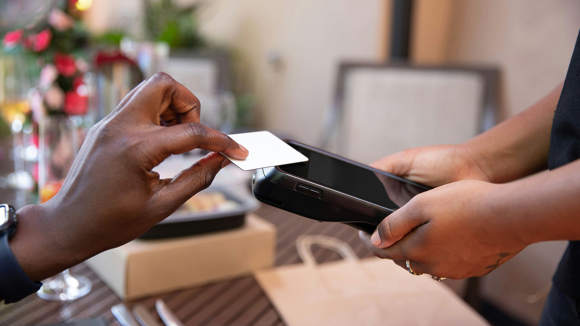 Person paying for meal at restaurant with debit card.