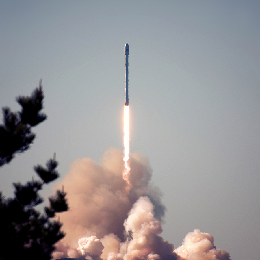 Rocket launch with bright flames and clouds of exhaust.